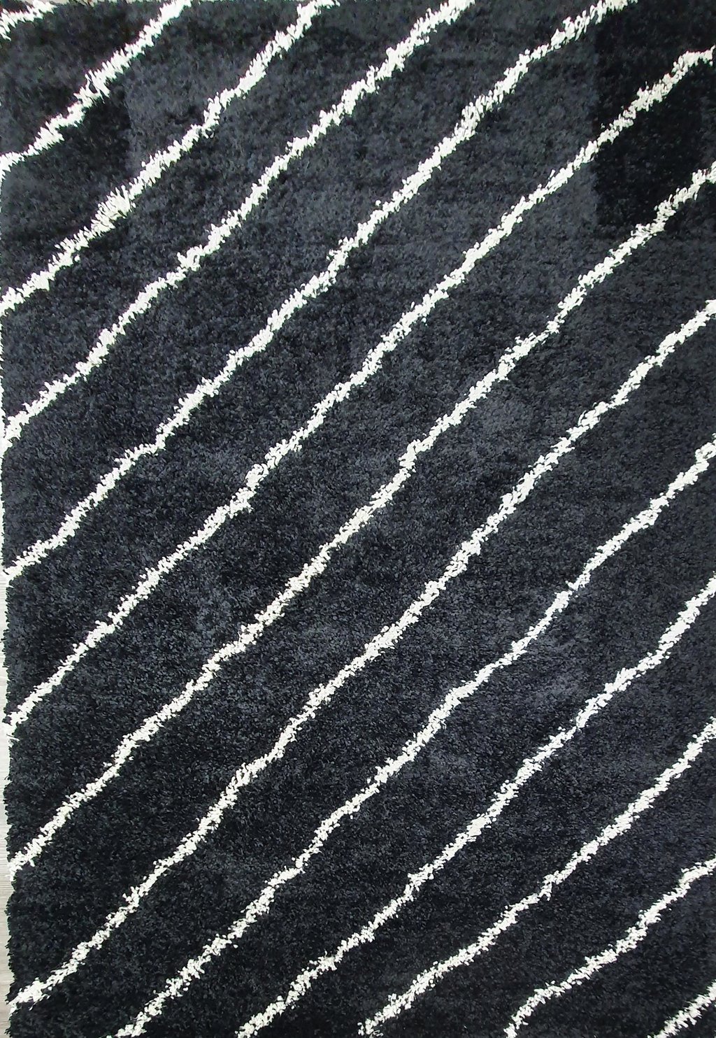 Solina matto 200x285 cm: Tyylikäs musta nukkamatto, joka tuo lämpöä ja eleganssia sisustukseen. Sopii täydellisesti olohuoneeseen tai makuuhuoneeseen.